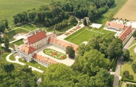 Aerial view of Schloss Thalheim with surrounding gardens and buildings.