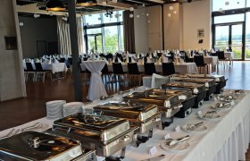 A festively decorated room with a buffet and laid tables.