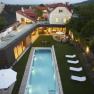 Aerial view of a modern house with pool and garden at dusk.