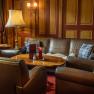 Cozy bar area with leather sofas, wooden table and lamps.