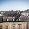View of the roofs of the neighboring buildings and blue sky.