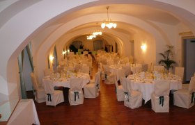 Elegant ballroom with set tables and chairs in Gloggnitz Castle.