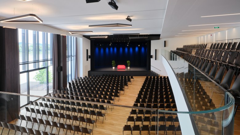Interior view of the Stadthalle Ybbs with empty rows of seats and stage.