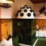 Cozy, traditional parlor with green tiled stove and wooden furniture.