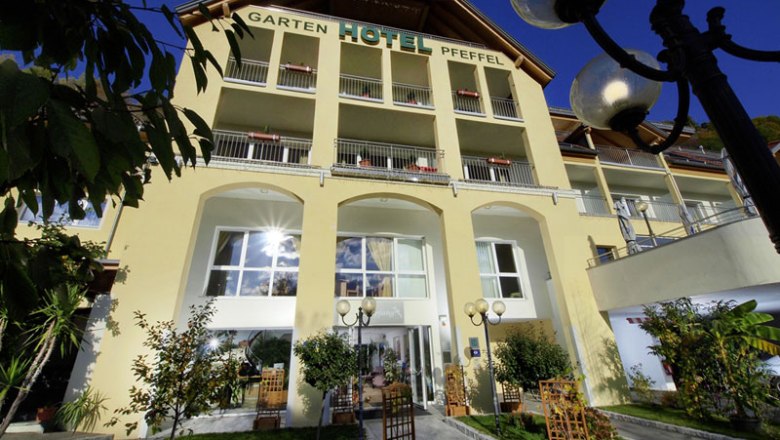 Exterior view of the Gartenhotel Pfeffel with yellow fa&ccedil;ade and balconies.
