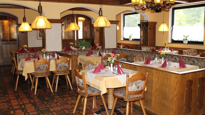 Cozy restaurant with wooden furniture and laid tables.