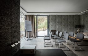 Modern conference room with gray chairs, flipchart and large windows.