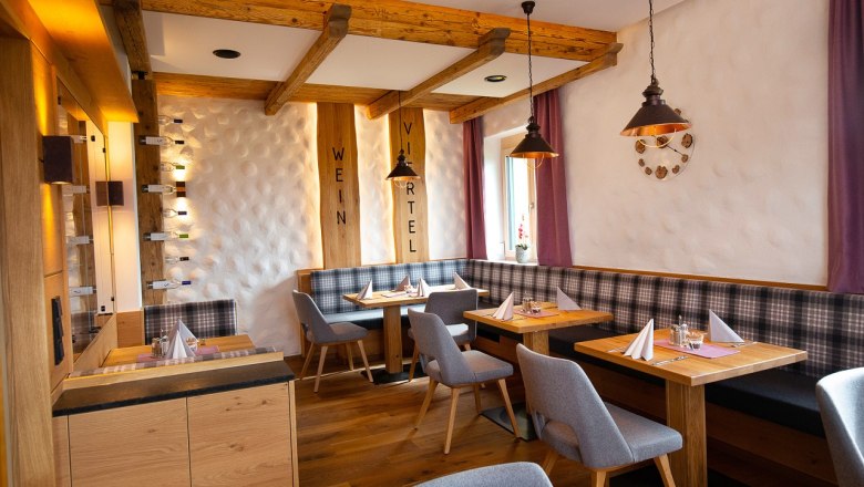 Cozy restaurant with wooden furniture, laid tables and purple curtains.
