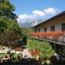 Inn with balcony full of flowers and mountain views.