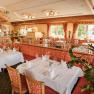 Elegant restaurant with laid tables and red upholstered furniture.