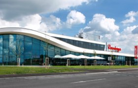 Modern building with glass fa&ccedil;ade and curved roof.