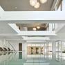 Indoor pool with sun loungers and large windows.