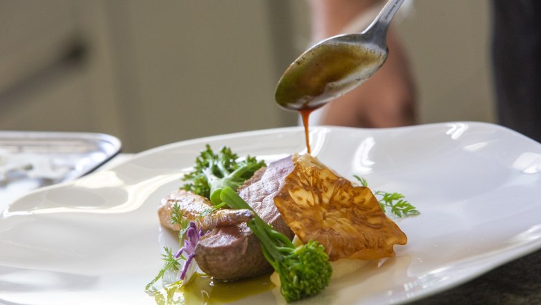 A gourmet dish is refined with a sauce.