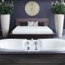 Modern spa area with bathtub, bed and plants.