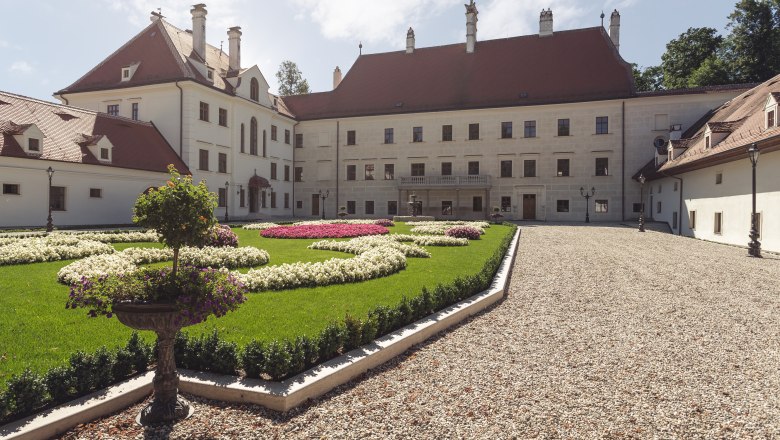 Schloss Thalheim with well-kept garden and gravel path.