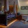Luxurious hotel room with four-poster bed and free-standing bathtub.