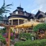 A traditional building with wooden balconies and a yellow parasol in the garden.