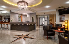 Hotel reception with bar and seating area.