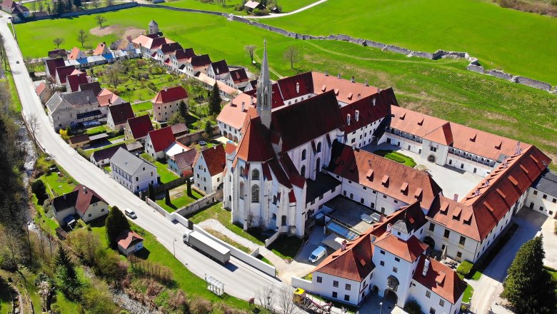 Aerial view of Gaming Charterhouse with surrounding buildings and green fields.