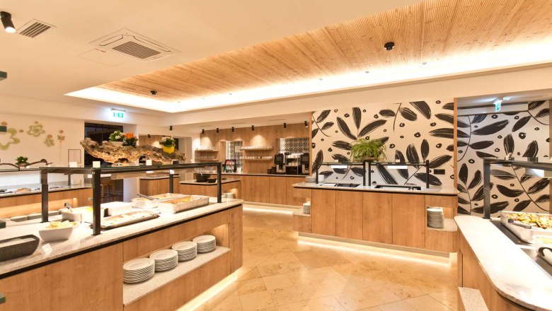Modern buffet area with wooden decor and plants.