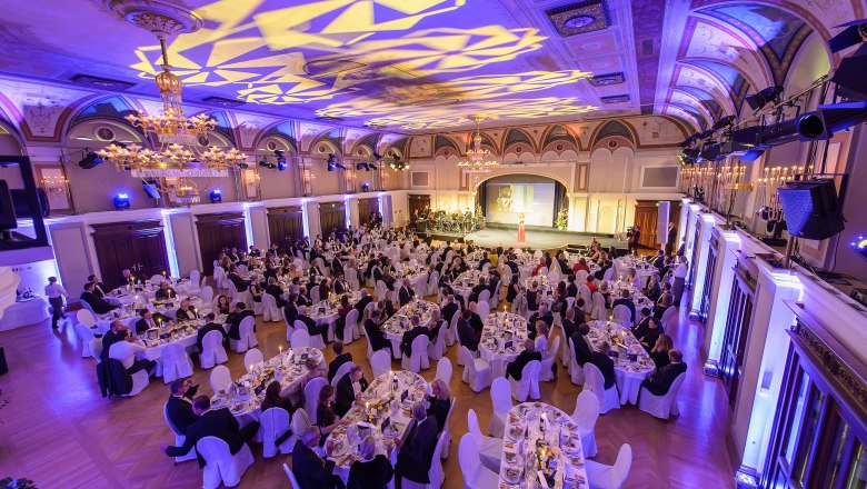 Elegant ballroom in the Congress Center Baden with laid tables and guests at an event.