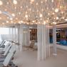 Modern spa relaxation area with loungers, hanging chairs and pool.
