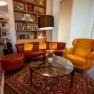 Cozy hotel lobby with red and yellow leather furniture, bookshelf and newspaper rack.