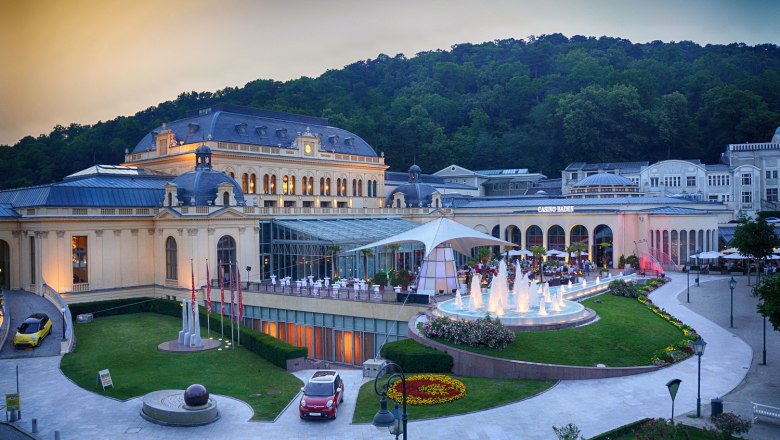 Exterior view of the Congress Center Baden with illuminated fountain and surrounding nature.