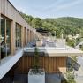 Modern spa terrace with wooden cladding and views of wooded hills.