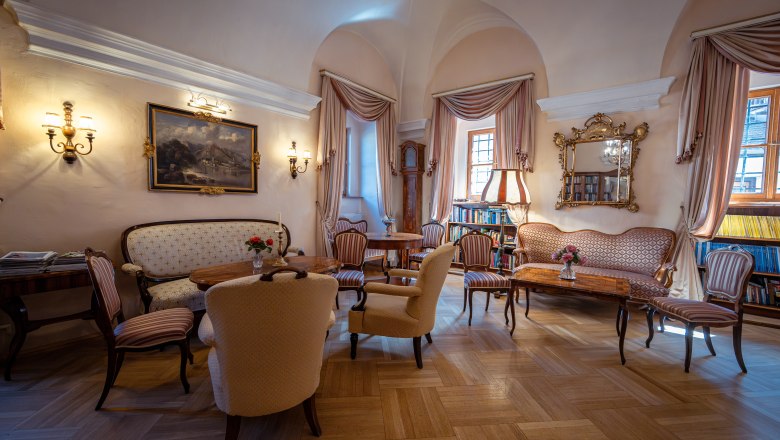 Elegant salon in Hotel Schloss D&uuml;rnstein with antique furniture, paintings and books.