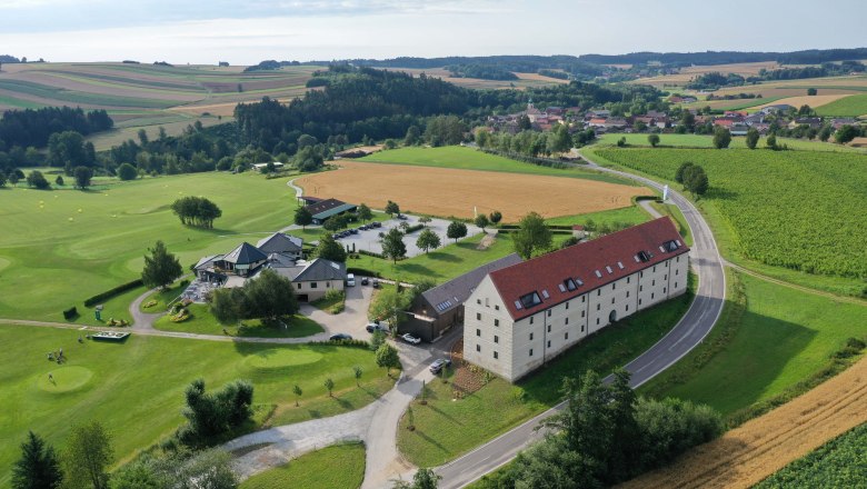 Aerial view of a country estate with golf course, fields and buildings in a rural setting.