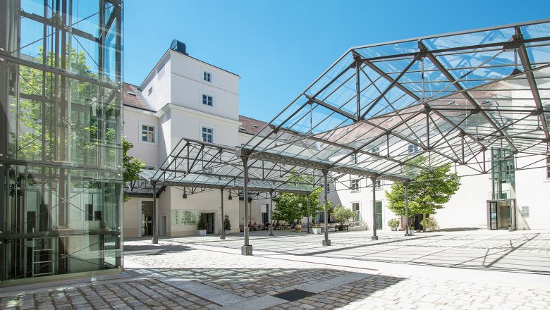 Inner courtyard of the Hotel Altes Kloster with glass roof and modern design.