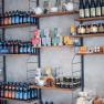 Shelves with various products such as bottles, tea packs and honey jars in a store.