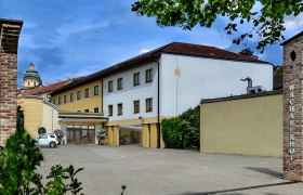 Exterior view of the Wachauerhof in Melk with parking lot and building facade.