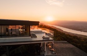 Modern hotel with terrace and river view at sunset and view over the Danube.
