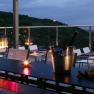 Evening terrace with candlelight, glasses of wine and a view of a city.