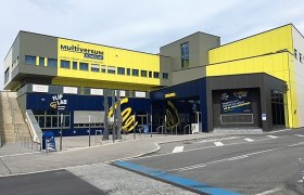 Exterior view of the Multiversum Schwechat, a modern building with yellow and blue facades.