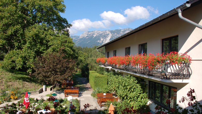 Inn with balcony full of flowers and mountain views.