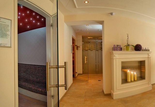 An elegant wellness area with fireplace, candles and sauna.