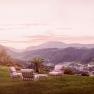 Seating area on a meadow with mountain views at sunset.