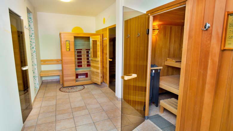 A modern sauna area with wooden walls and several sauna cabins.
