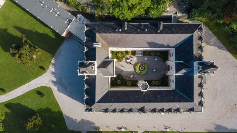 Aerial view of Schloss Hernstein with inner courtyard and surrounding garden.