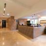 A hotel reception area featuring a modern design, wooden elements, and a large reception desk.