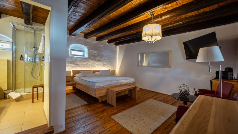 Comfortable room with wooden floor, double bed, shower and modern furnishings.