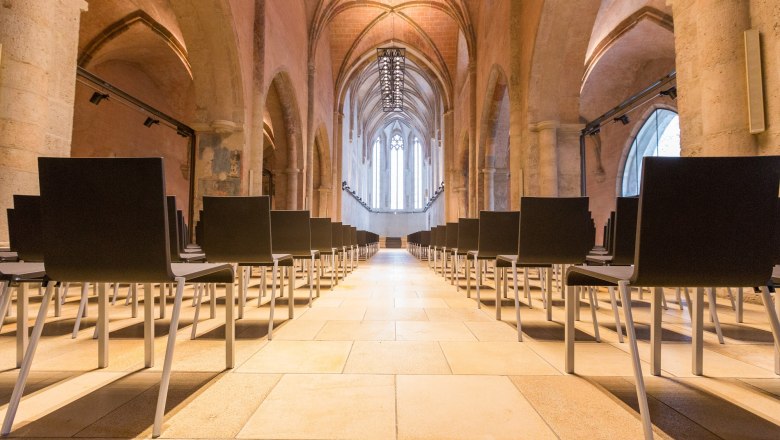 Interior view of a Gothic hall with rows of chairs.