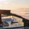 Modern building with terrace above a sea of fog at sunrise.