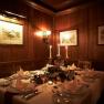 Festively laid table in a cozy wine bar with candlelight and wooden walls.