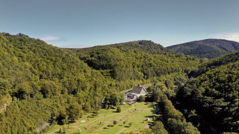 Aerial view of the Krainerhütte amidst wooded hills.