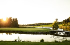 Golf course with pond and bridge at sunset at the Haugschlag golf resort.