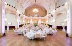 Elegant hall with laid tables and chandeliers.